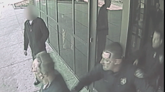 In the upper right corner of the surveillance video, there is a reflection in the glass door that shows the police cruiser hitting Officer Sekou Reid-Bey and speeding off.