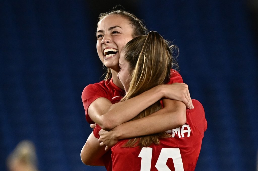 Canada's midfielder Julia Grosso, left, hugs forward Jordyn Huitema after scoring the winning penalty during the penalty shoot-out of the Tokyo 2020 Olympic Games women's final football match between Sweden and Canada at the International Stadium Yokohama in Yokohama on Aug. 6, 2021.