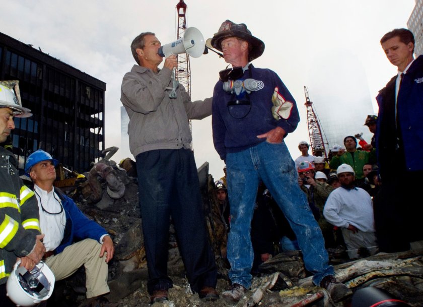Then-President George W. Bush stands with firefighter Bob Beckwith, right, on a burnt fire truck in front of the World Trade Center during a tour of the devastation on Sept. 14, 2001.