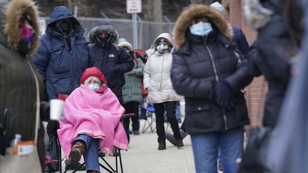 FILE - Judy McKim, center left, waits in line with others for the COVID-19 vaccine in Paterson, N.J., Thursday, Jan. 21, 2021. On March 11, 2024, an independent report examining New Jersey's response to the pandemic said the state and nation were unprepared for it, adding the state is still underprepared for the next crisis. (AP Photo/Seth Wenig, File)