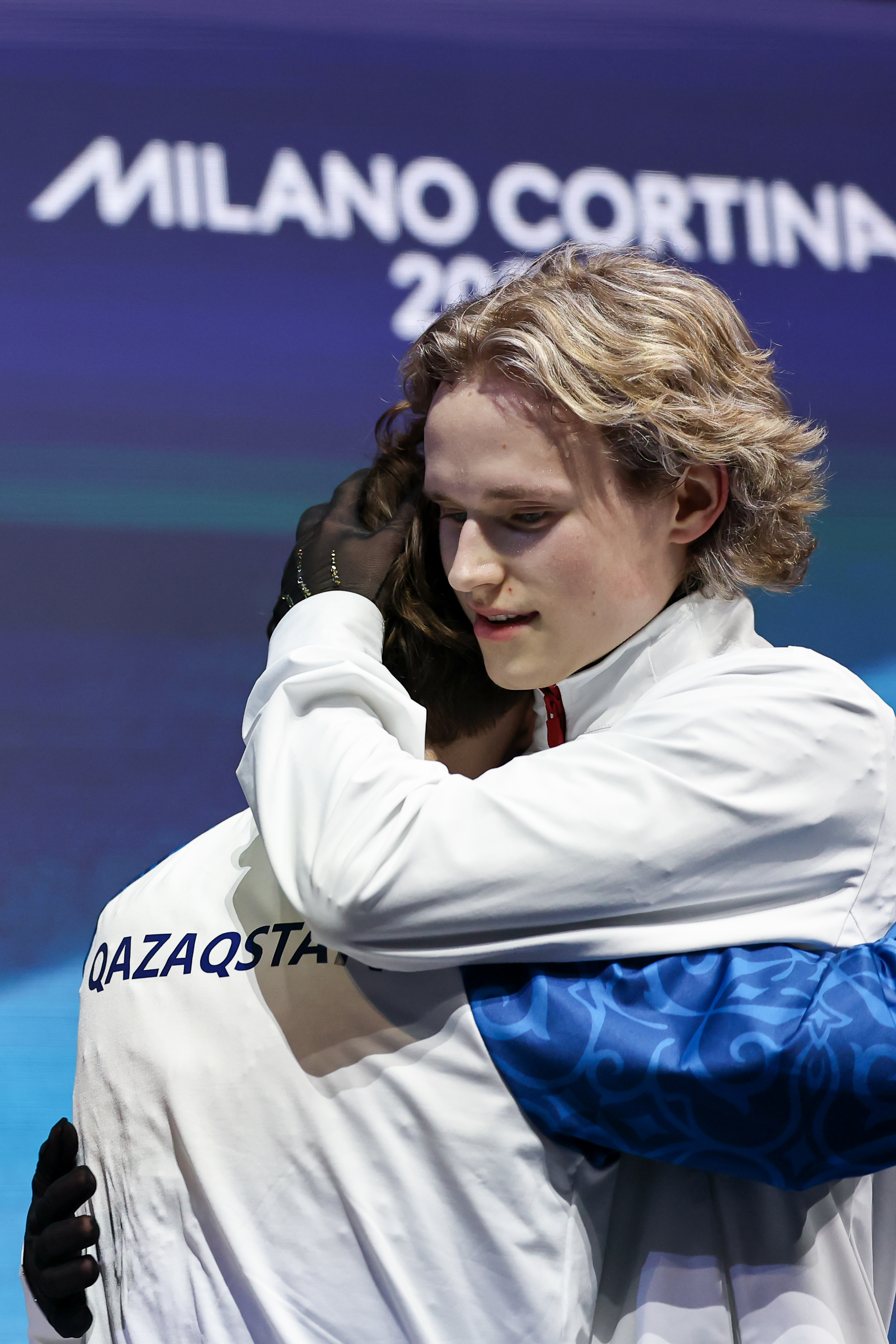 Mikhail Shaidorov of Team Kazakhstan and Ilia Malinin of Team United States embrace following the Men's Single Skating event.