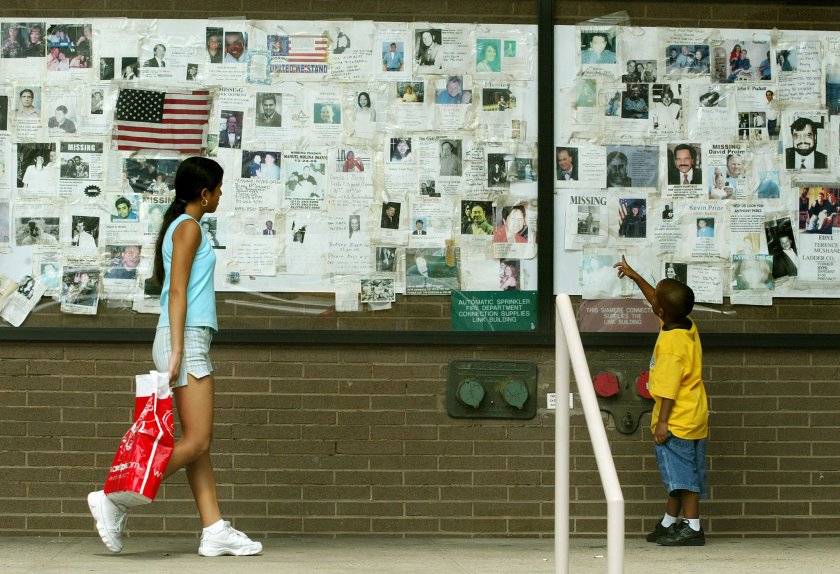 Crystal (L) and Jordan Tirado view Sept. 11 missing person posters August 22, 2002, in New York City. The posters were still attached to a wall outside Saint Vincent's Hospital.