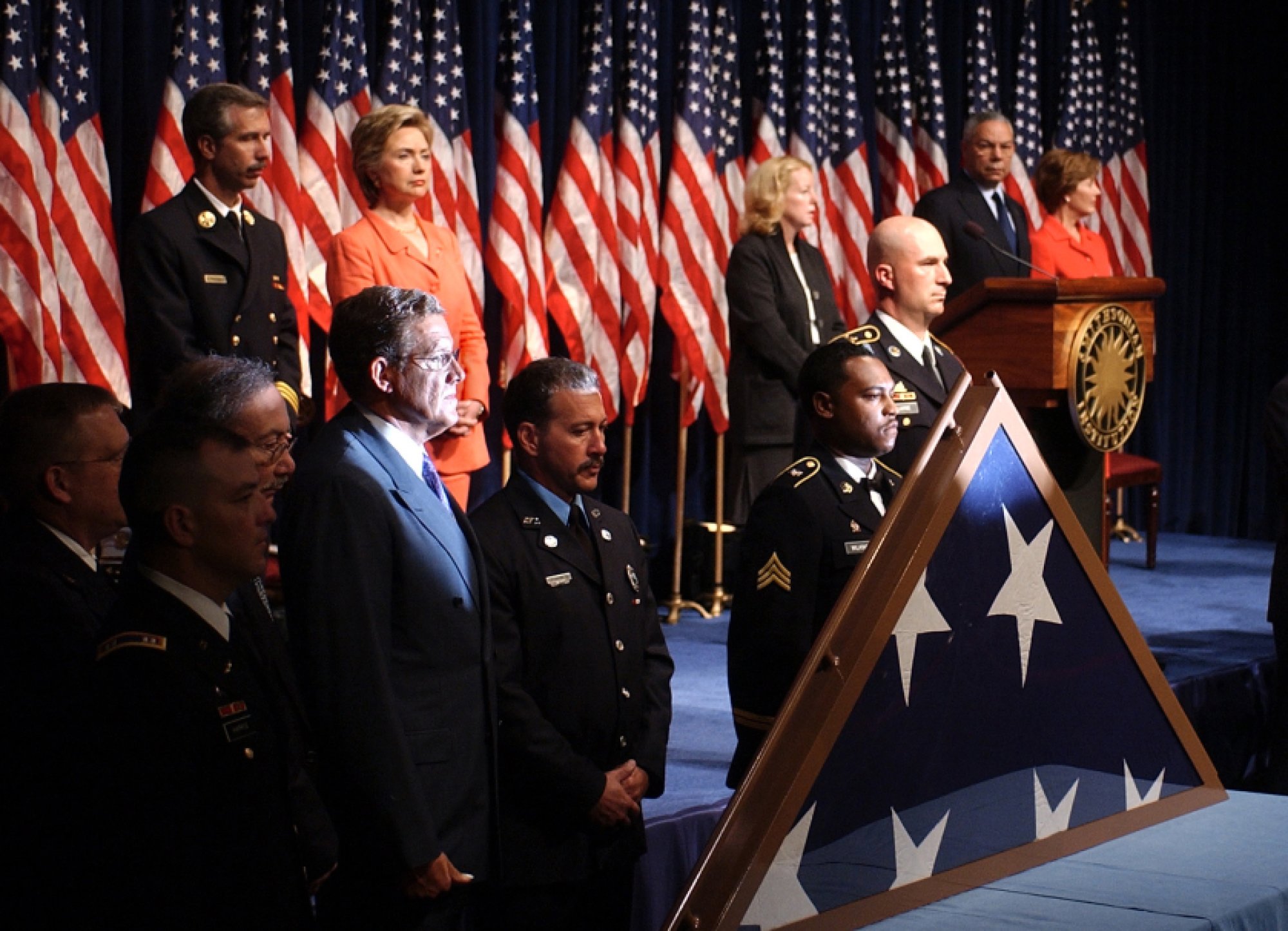 With the flag that hung over the Pentagon last year after the terrorist attack in the foreground, dignitaries and military personnel take part in a dedication ceremony for the September 11 Bearing Witness to History exhibit, Tuesday, Sept. 10, 2002 at the Smithsonian's American History Museum. Back row from left are, New York Fire Chief Joseph Pfeifer, Sen. Hillary Rodham Clinton, D-N.Y., Sheila Burke, Smithsonian undersecretary for American Museums and National Programs, Secretary of State Colin Powell and first lady Laura Bush. The flag was shown Tuesday before being returned to the Pentagon.