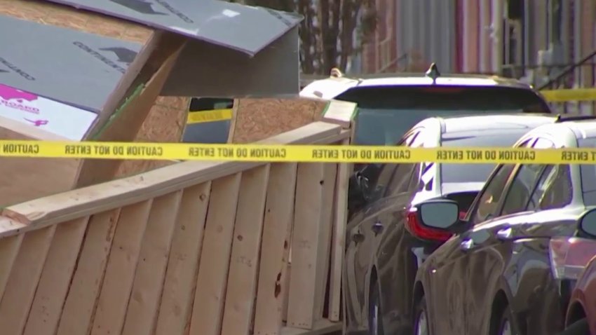 Wooden debris is strewn along Watkins Street in Philadelphia's Point Breeze neighborhood after a house collapse.