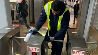 Man wipes down transit turnstiles