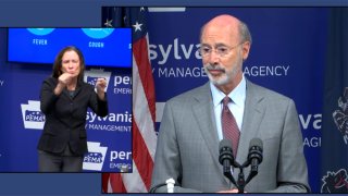 A man at a podium with a sign language interpreter