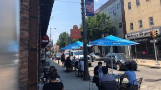 Diners at outside tables along a street