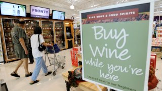 In this June 25, 2010 photo, shoppers walk past the wine selection offerings from the Pennsylvania Liquor Control Board's self-serve wine kiosk at a Giant food store in Harrisburg, Pa.