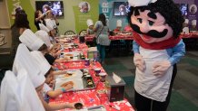 Chuck E. Cheese's Chef Pasqually, right, interacts with children as they learn how pizza is made at the San Antonio Chuck E. Cheese's 2017 reopening, Aug. 9, 2017.