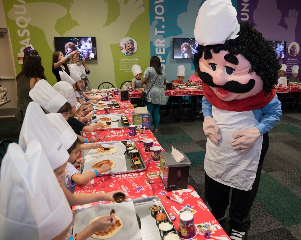 Chuck E. Cheese's Chef Pasqually, right, interacts with children as they learn how pizza is made at the San Antonio Chuck E. Cheese's 2017 reopening, Aug. 9, 2017.