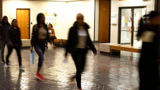 In this Nov. 19, 2019, photo, asylum seekers from Central America and Cuba follow an Immigration and Customs Enforcement guard into the Richard C. White Federal Building in El Paso, Texas.