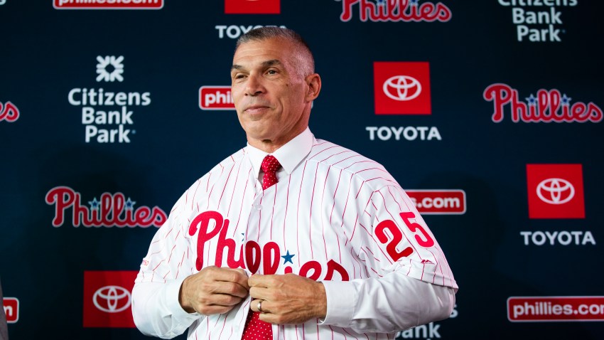 Joe Girardi puts on his uniform during a news conference