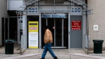 A pedestrian walks past the shuttered Hahnemann Hospital in Philadelphia, Wednesday, March 25, 2020.