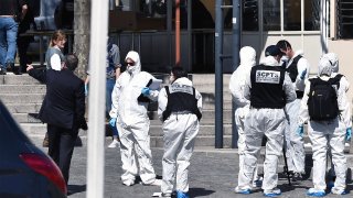 Police officers investigate after a man wielding a knife attacked residents venturing out to shop in the town under lockdown, Saturday April 4, 2020 in Romans-sur-Isere, southern France.