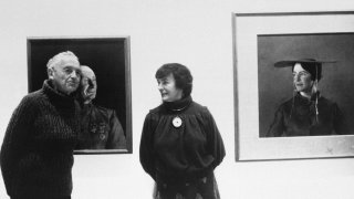 American artist Andrew Wyeth poses with his wife Betsy in front of his paintings "The Patriot," left, and "Maga's Daughter" for which Betsy was the model, in this 1985 photo. Betsy James Wyeth, the widow, business manager and muse of painter Andrew Wyeth, died Tuesday, April 21, 2020, at age 98, according to the Brandywine River Museum of Art in Chadds Ford, Pa., which she helped found.