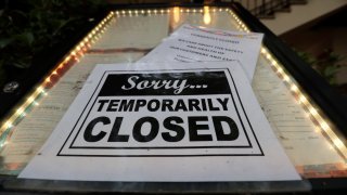 FILE - In this April 28, 2020 file photo, a closed sign is posted at a restaurant along the River Walk in San Antonio.