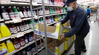 In this Wednesday, June 3, 2020 photo, Juan Santos stocks shelves at the Presidente Supermarket in the Little Havana neighborhood of Miami.