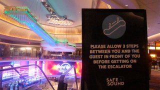 This June 24, 2020 photo shows a sign in the Hard Rock casino in Atlantic City N.J. instructing customers to maintain a distance on the escalator to prevent the spread of the coronavirus.