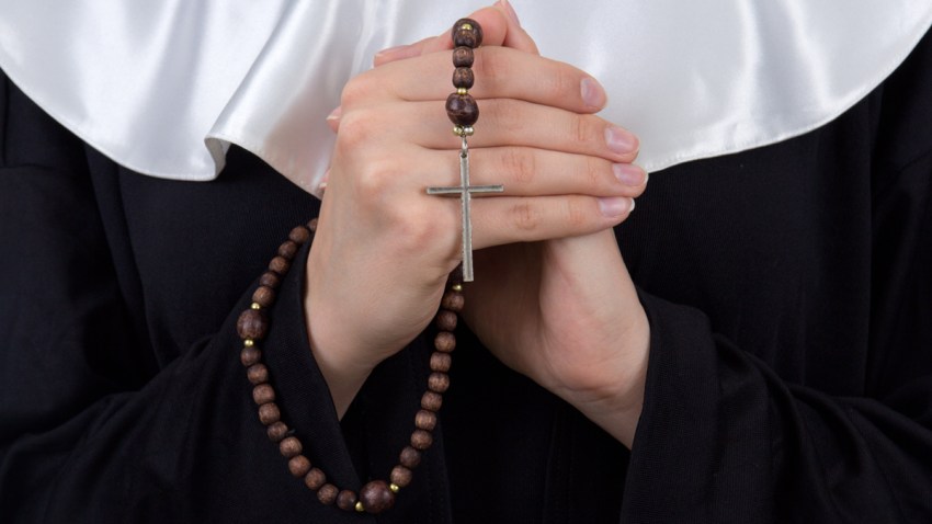 close up of rosary in nun hands