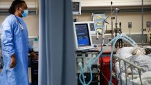 In this April 20, 2020, file photo, a nurse looks over at a COVID-19 patient who is attached to a ventilator in the emergency room at St. Joseph's Hospital in Yonkers, N.Y.