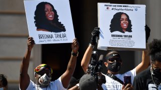 Signs are held up showing Breonna Taylor during a rally in her honor on the steps of the Kentucky State Capitol in Frankfort, Ky., Thursday, June 25, 2020.