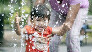 A young boy plays in water.