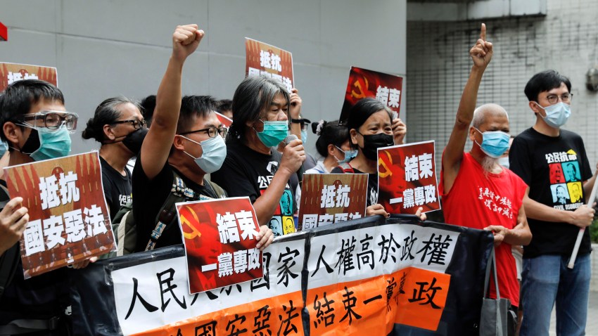 Pro-democracy Leung Kwok-hung, center, and others protesters shout slogans " Stop One Party Rolling" before they march toward the flag raising ceremony marking the anniversary of the Hong Kong handover to China in Hong Kong, Wednesday, July 1, 2020. Hong Kong marked the 23rd anniversary of its handover to China in 1997, one day after China enacted a national security law that cracks down on protests in the territory.