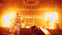 Fire shoots from the floor as Rammstein performs on stage.