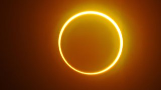 The moon moves in front of the sun in a rare "ring of fire" solar eclipse