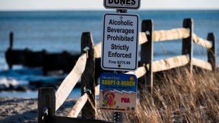 A sign warning of consuming alcoholic beverages is seen on the boardwalk in Ocean City, New Jersey on January 8, 2020. – Pizza joints and popcorn stands jostle for attention all along the boardwalk in Ocean City, New Jersey — but good luck finding a drink. A full century after the Prohibition era began in America, being dry has become a trademark for the beachside resort.In between ads for local churches, signs posted all along the Atlantic serve as a stern warning to anyone tempted to crack open a beer on the beach: “Alcoholic beverages prohibited. Strictly enforced. Fine $275.” Although Prohibition ended nationwide in 1933, the island of 11,000 residents is one of hundreds of American cities and jurisdictions that continue to ban alcohol sales. (Photo by ANDREW CABALLERO-REYNOLDS / AFP) (Photo by ANDREW CABALLERO-REYNOLDS/AFP via Getty Images)