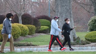 People, wearing medical masks as a precaution against the new type of coronavirus (COVID-19) pandemic, walk through the road at Eagle Rock Reservation Park in New Jersey, United States on April 7, 2020.