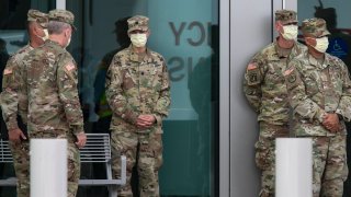 Members of the U.S. Army Corps of Engineers stand outside the Miami Beach Convention Center as they prepare to build a coronavirus field hospital inside the facility