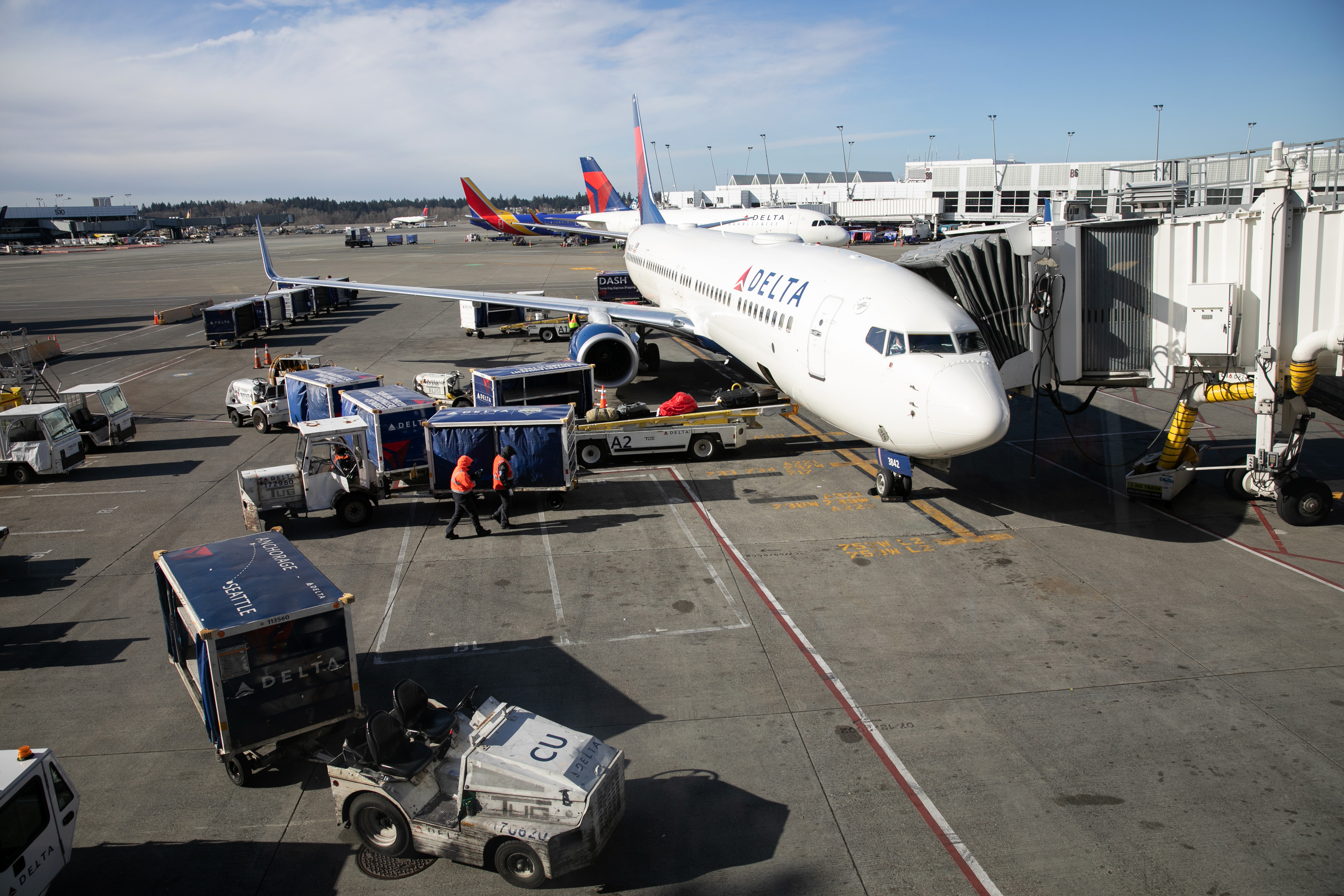 A ground crew prepares to unload luggage from an arriving Delta Airlines flight