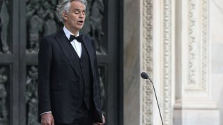 This photo taken on April 12, 2020 shows Italian tenor and opera singer Andrea Bocelli sing during a rehearsal on a deserted Piazza del Duomo in central Milan, prior to an evening performance without public for the world wounded by the pandemic, during the country's lockdown aimed at curbing the spread of the COVID-19 infection, caused by the novel coronavirus.