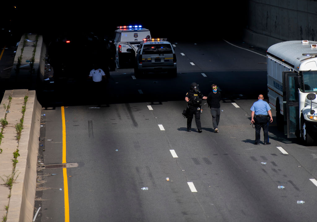 PHILADELPHIA, PA – JUNE 01: A police officer arrests a protestors on the Vine Street Expressway after tear gas and rubber bullets were shot to disperse the crowd after a march on June 1, 2020 in Philadelphia, Pennsylvania. Demonstrations have erupted all across the country in response to George Floyd’s death in Minneapolis, Minnesota while in police custody a week ago. (Photo by Mark Makela/Getty Images)