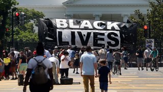 A Black Lives Matter banner hangs on the fence around the White House to protest the death of George Floyd, on June 10, 2020.