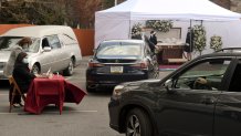Muhlenberg, PA - April 16: Cars pull in to the drive up viewing, at the left is a table staffed by Funeral Director Elizabeth Candelori, where guest's names are entered into an electronic guestbook . At the Stitzel Family Funeral Home on Kutztown Road in Muhlneberg Thursday afternoon April 16, 2020 where the funeral for Tom Minh Nguyen was being held as a drive-up viewing so that mourners could pay their respects without getting out of their cars and still maintaining social distancing during the Coronavirus / COVID-19 crisis. (Photo by Ben Hasty/MediaNews Group/Reading Eagle via Getty Images)