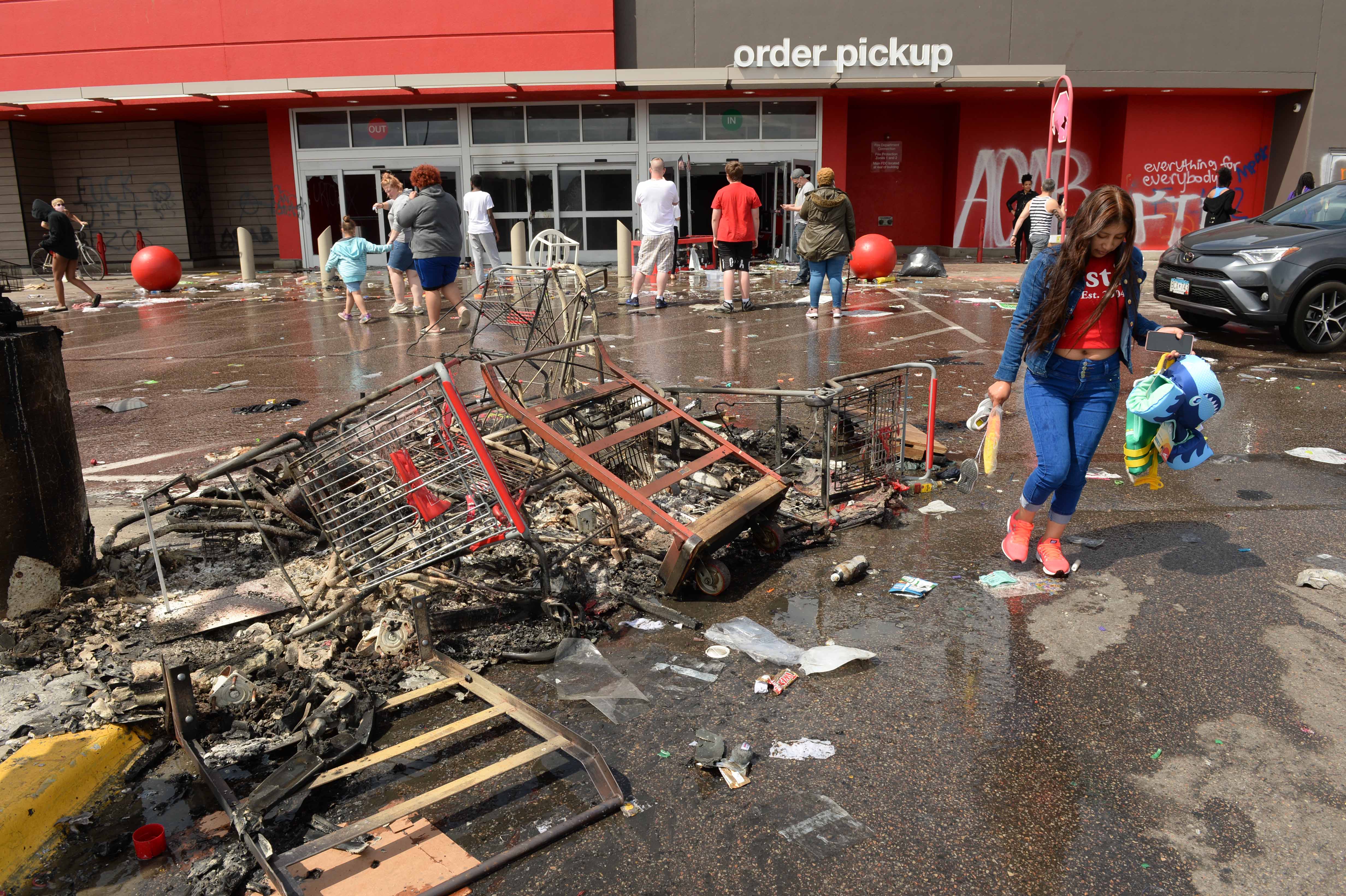 Looters carry items out of a Target store in the aftermath of extensive rioting, looting and arson in shopping and commercial areas of South Minneapolis