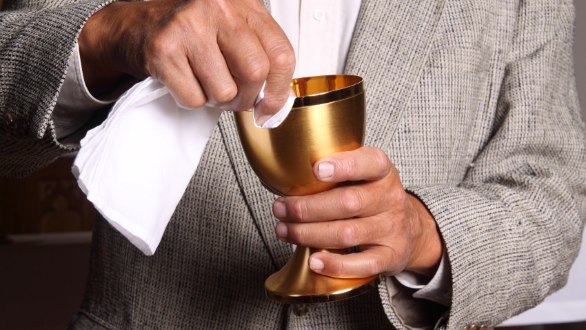 File photo of a man wiping the chalice during communion.