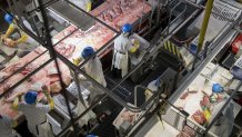 In this April 12, 2017, file photo, employees butcher pork at a Smithfield Foods Inc. pork processing facility in Milan, Missouri.