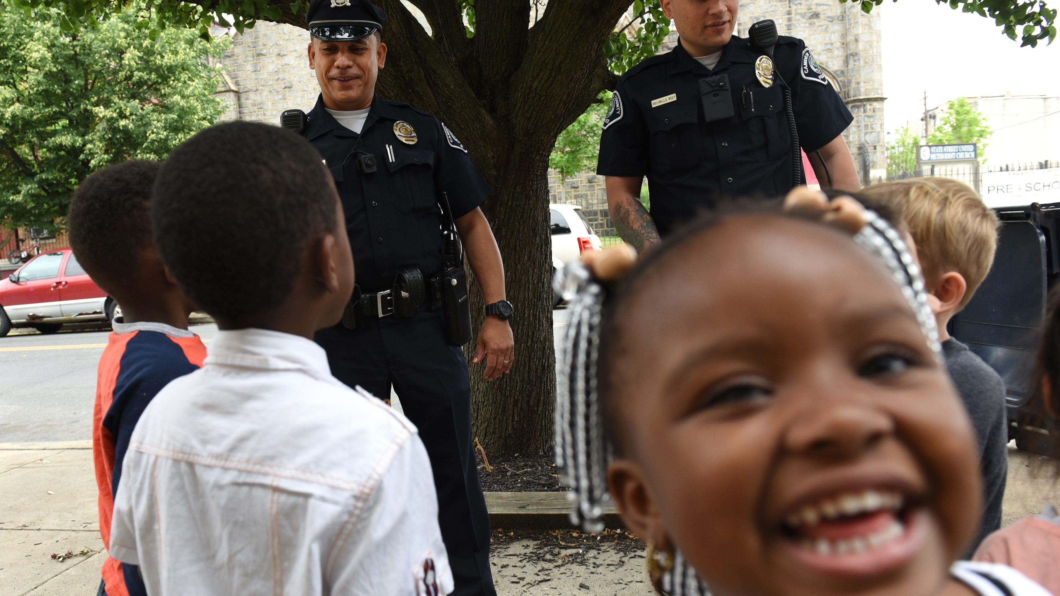 Jurnee Niani Walker-Hicks smiles as Camden County Police Department officers  Louis Sanchez and Jose Delvalle are seen on foot patrol in Camden, New Jersey, on May 24, 2017. 
In 2013  the city of Camden, New Jersey, dissolved its police force, replacing it with a new county-run department where they are turning around a city that had one of the highest crime rates in the country. Police reform and falling crime statistics turned Camden into a poster child for better policing.  