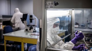 In this Feb. 5, 2020, file photo,scientists are at work in the VirPath university laboratory, classified as “P3” level of safety as they try to find an effective treatment against the new coronavirus.