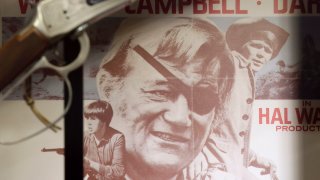 A movie poster showing John Wayne from True Grit is shown in a display case in the John Wayne Museum, Thursday, May 14, 2015, in Winterset, Iowa. True Grit was written in 1968 by Charles Portis, who died Monday.