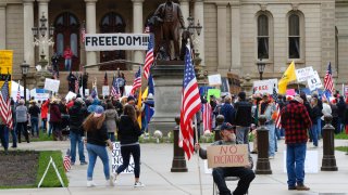 Protesters rally at the State Capitol in Lansing, Mich., Thursday, April 30, 2020. Hoisting American flags and handmade signs, protesters returned to the state Capitol to denounce Gov. Gretchen Whitmer’s stay-home order and business restrictions due to coronavirus COVID-19 while lawmakers met to consider extending her coronavirus emergency declaration hours before it expires.