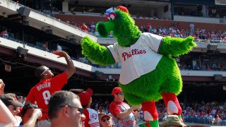 The Phillie Phanatic high-fives a fan during a game between the Philadelphia Phillies and the Atlanta Braves at Citizens Bank Park