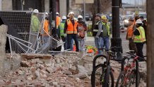 Construction workers look at the rubble from a building after an earthquake, March 18, 2020, in Salt Lake City. A 5.7-magnitude earthquake shook the city and many of its suburbs.