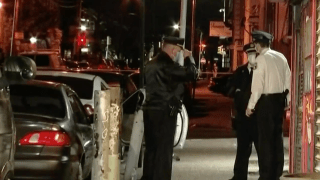 Philadelphia police investigators stand near a car where a man was shot dead Friday, May 8, 2020.