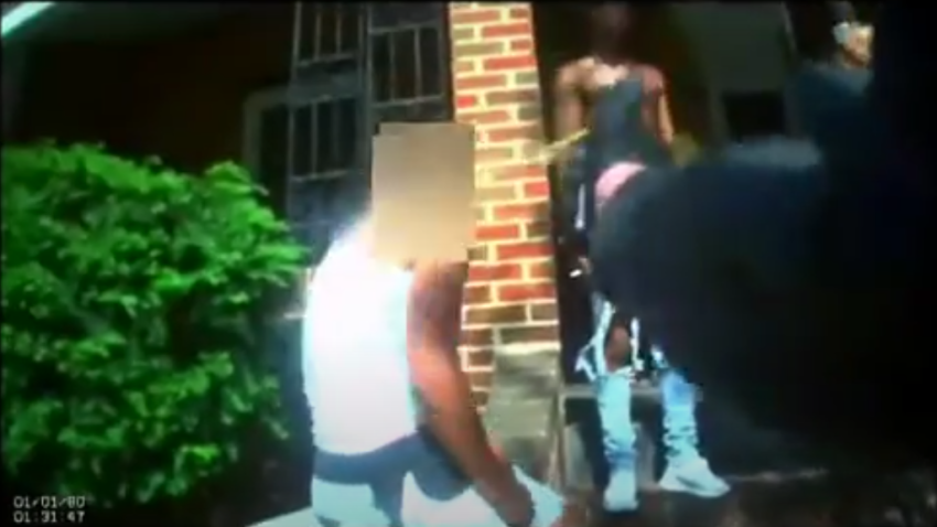 A still image from a body camera shows a New Jersey police officer pepper spraying two people.