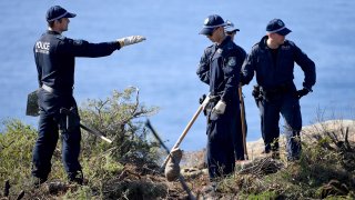 Police search a headland in Sydney, Tuesday, May 12, 2020, following an arrest in relation to the death of a man in 1998. More than 30 years after American mathematician Scott Johnson died after falling off a cliff in Sydney, a man has been charged with his death in an apparent gay hate crime that police believe was one of many over several decades in Australia's largest city.
