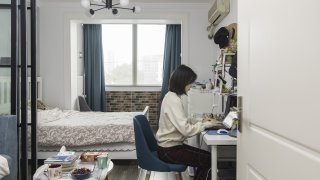 In this file photo, Claire Tu, an employee at Reprise Digital, works from her home in Shanghai, China, on Monday, March 9, 2020.